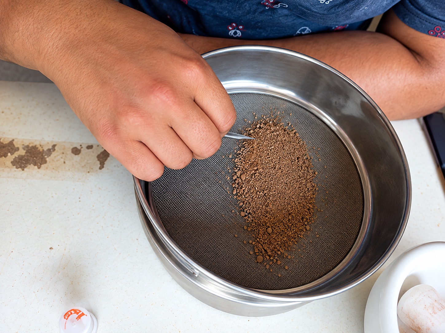 Sieved soil sample in a metal bowl during Amazon PyroCarbon laboratory processing