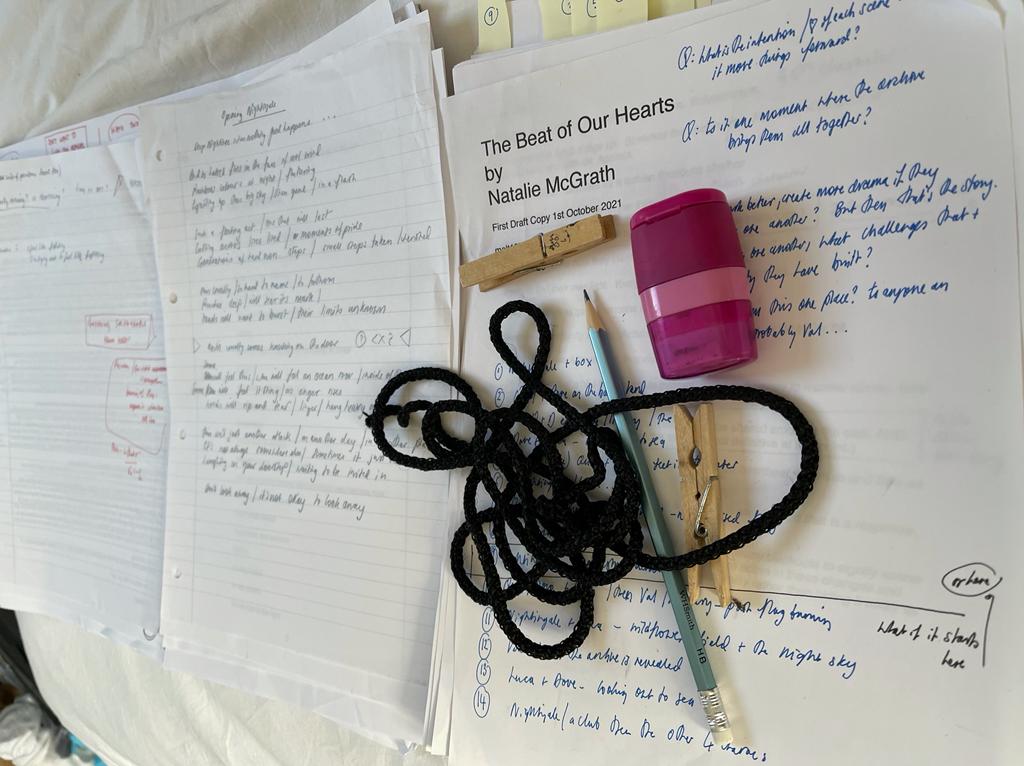 Photo is of sheets of paper associated with the draft of The Beat of Our Hearts, as well as some stationary and scribblings on the play.