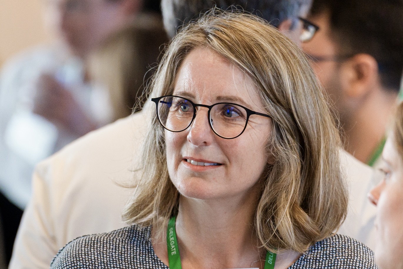 White woman with shoulder length hair and glasses
