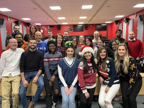 Group of people wearing Christmas jumpers and Christmas hats