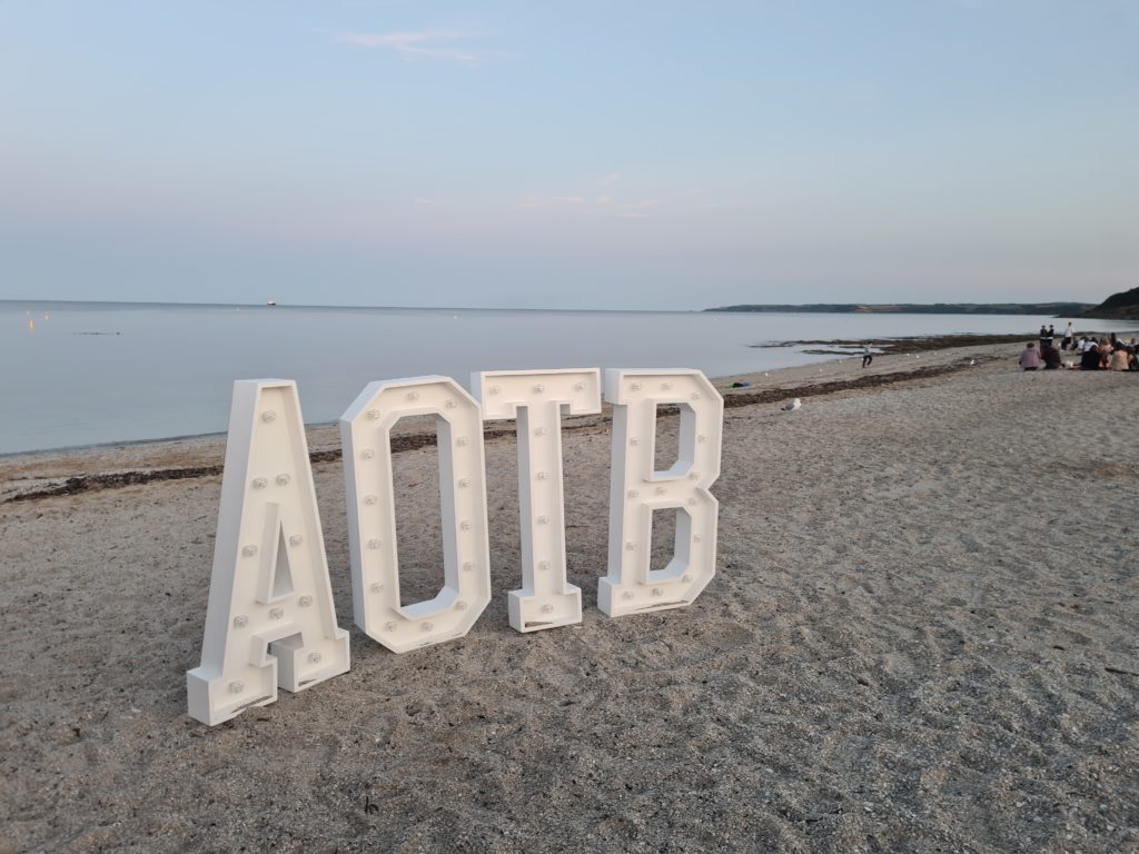 Photo of 'AOTB' letters on a beach. 
