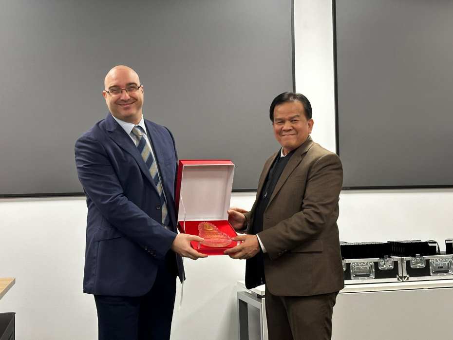 One of the delegates from Thailand is presented with a University of Exeter souvenir by Dr Costantino Grasso