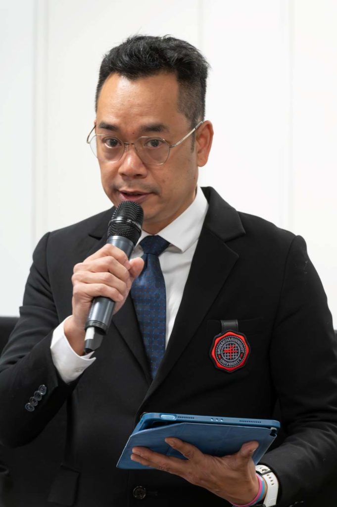 One of the delegates from Thailand holding a microphone and a small tablet.