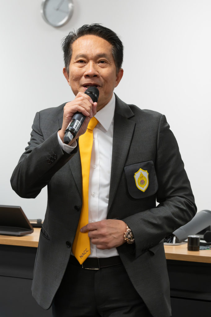 One of the delegates from Thailand holding a microphone and a small tablet.