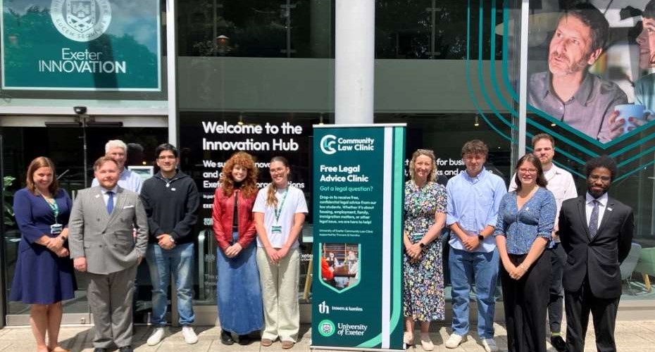 A group of Law students and local legal professionals stood outside the Exeter Innovation Hub. there is a banner in the middle of the group.