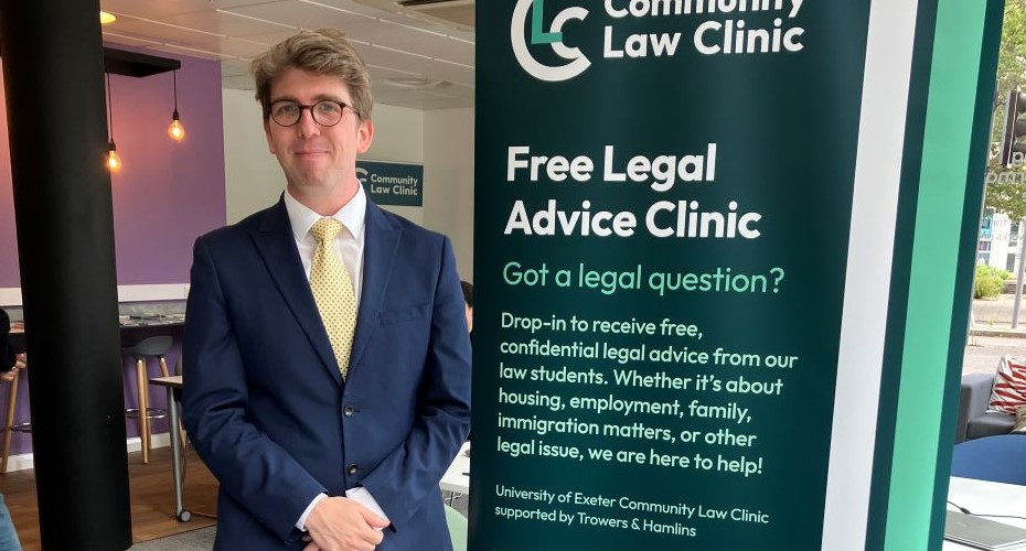 An alumnus of the university guest stood next to the Free Legal Advice Clinic banner which asks 'Got a legal question? Drop in to receive free confidential legal advice from our law students. Whether it's about housing, employment, family, immigration matters or other legal issue, we are here to help! 