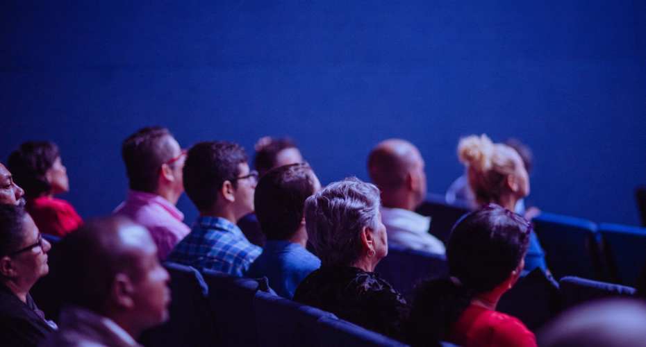 a couple of rows of people seated in a conference style setting
