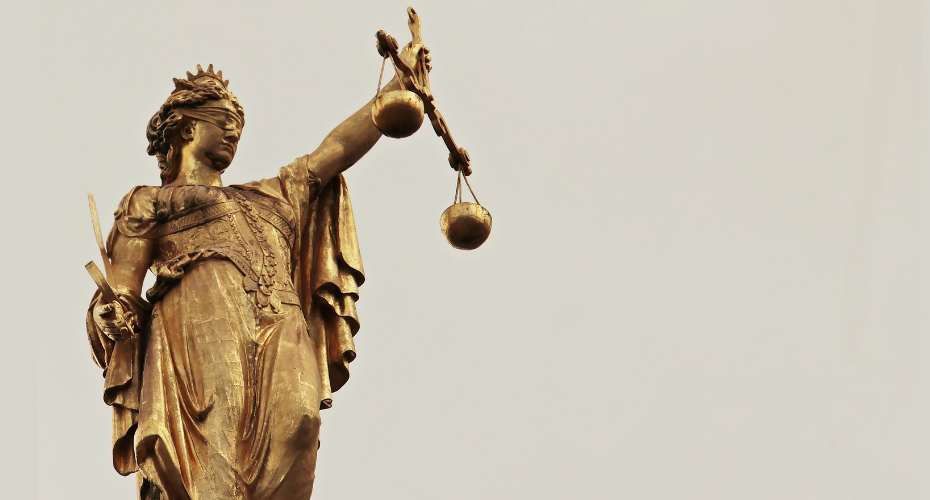 A gold statue of the scales of justice