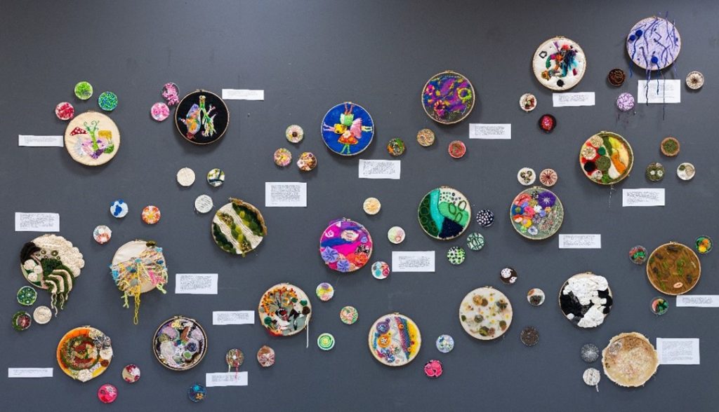 Embroidery hoops on display at the mycology art exhibition.