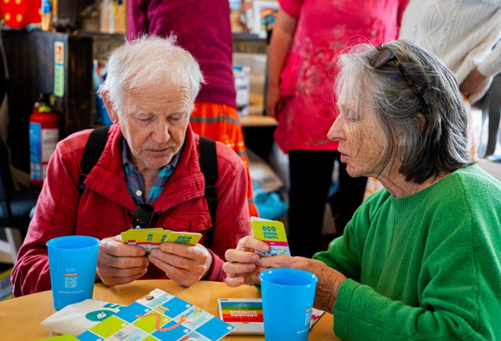 Two people playing top trumps around a table