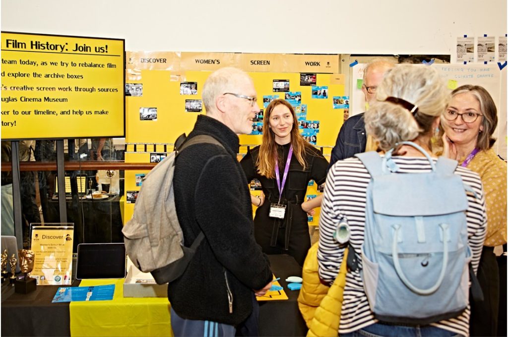 A group of people chatting around a stall