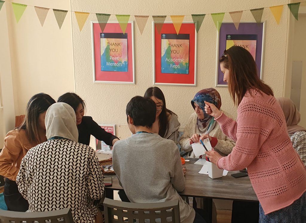 A group of people gathered round a badge maker