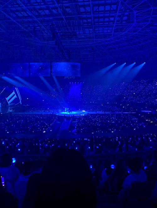 A K-POP concert with the stage lit with blue lights