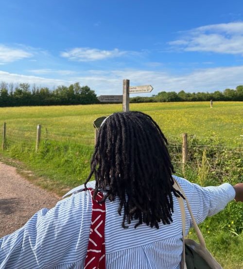 Student walking through fields in the sunshine