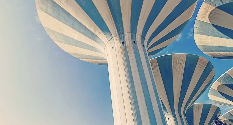 Blue and white striped water towers against a blue sky