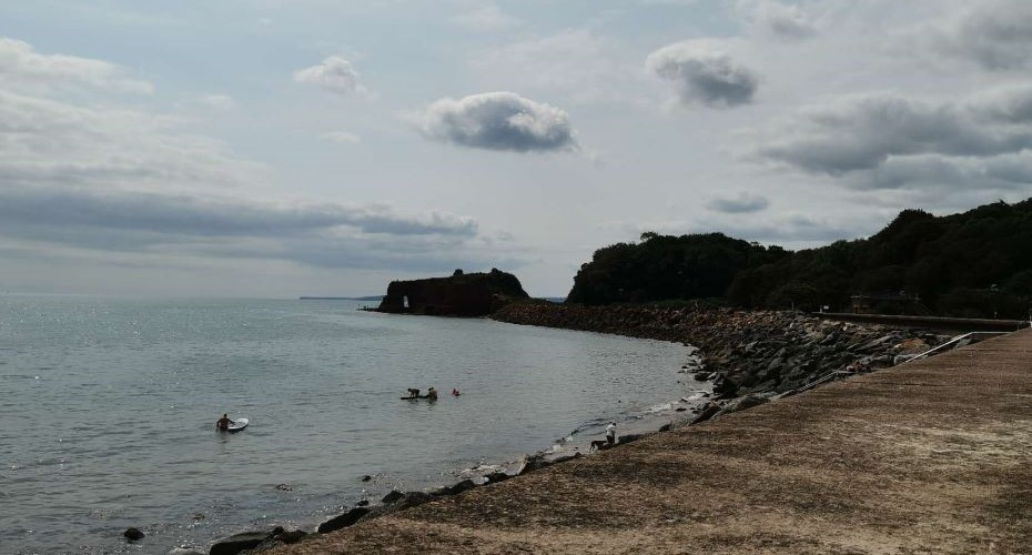 Beach with paddle boarders on a cloudy day