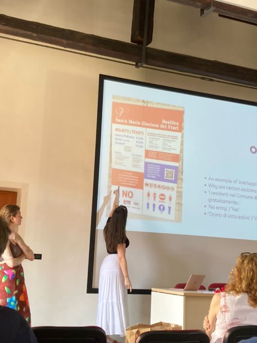 Female student pointing to a presentation slide being projected onto a classroom wall