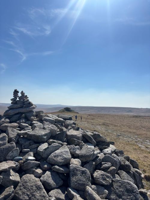 Moorland on a sunny day with two walkers in the distance