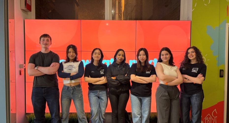 Student group photo in front of a Students' Guild branded wall