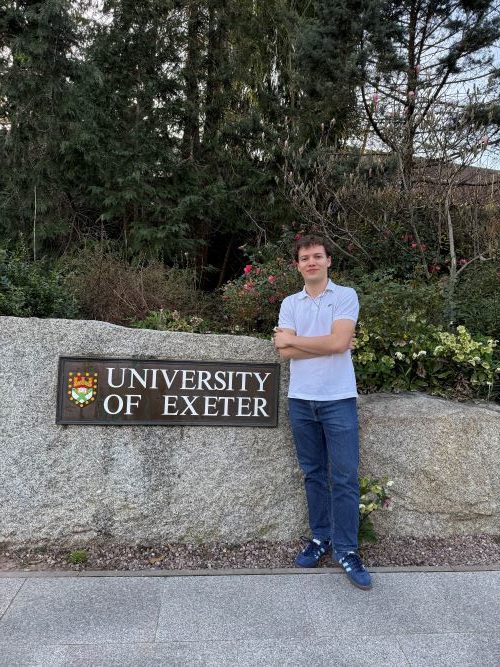 Student in front of the University of Exeter rock sign