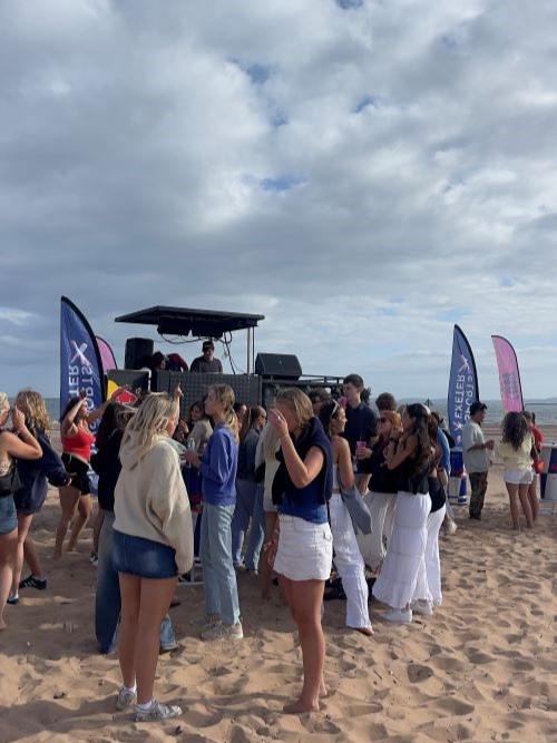 Students at a temporary bar on a beach