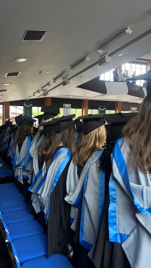Row of students wearing graduation caps and gowns