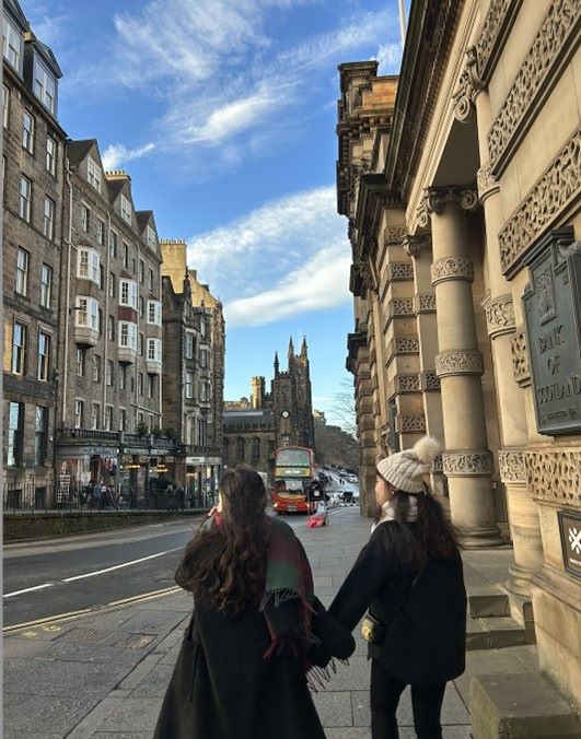 Photo of two female students walking along an Edinburgh street on a sunny winter day