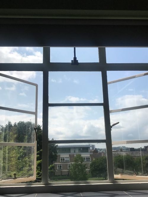 Open windows looking out over blue skies and Streatham Campus