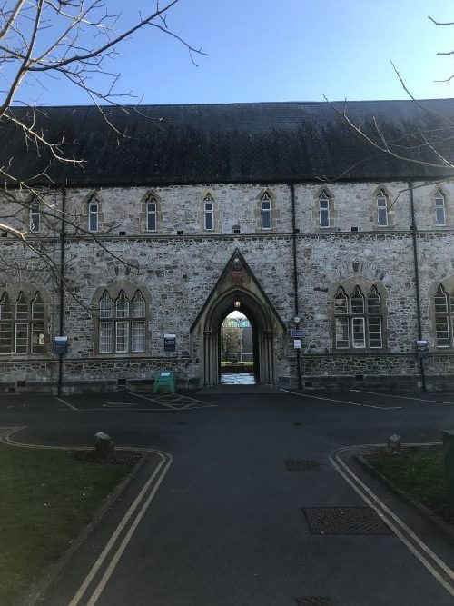 Large stone building with a central archway to St Luke's campus