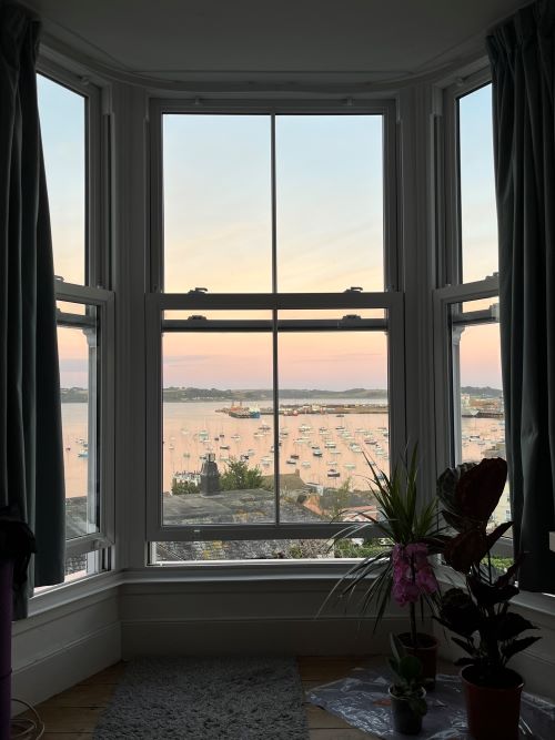View out of a large window of a harbour at sunrise