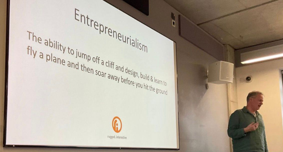 A speaker giving a presentation titled 'Entrepreneurialism'