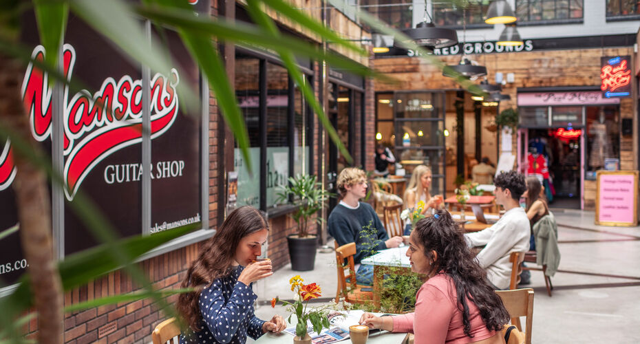 McCoys Arcade on Fore Street in Exeter, showing students sitting outside a coffee shop.