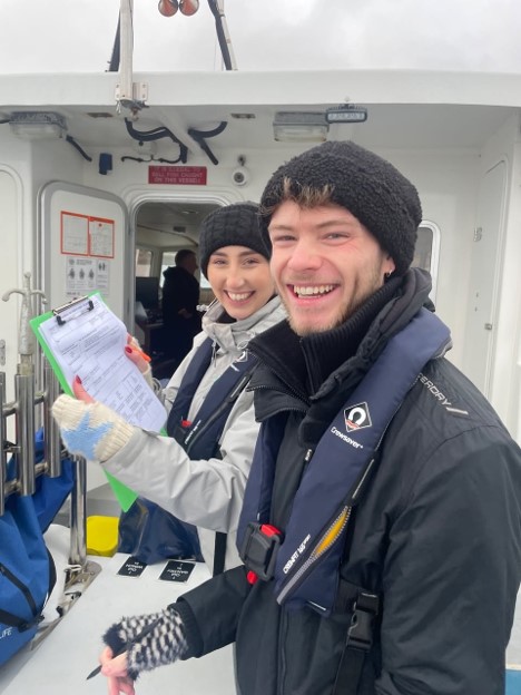 Ethan and another researcher on a boat