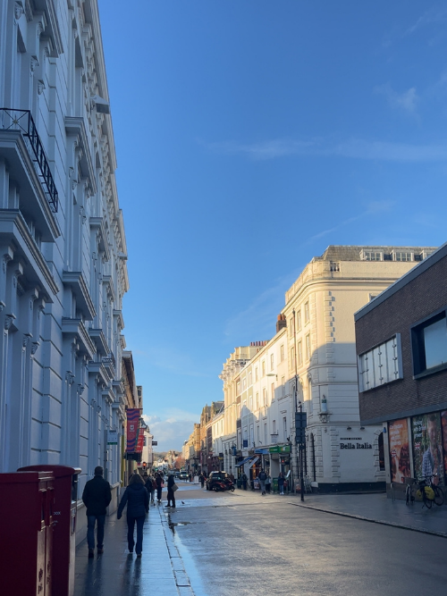 Looking down Queen Street in Exeter city centre on a bright day.
