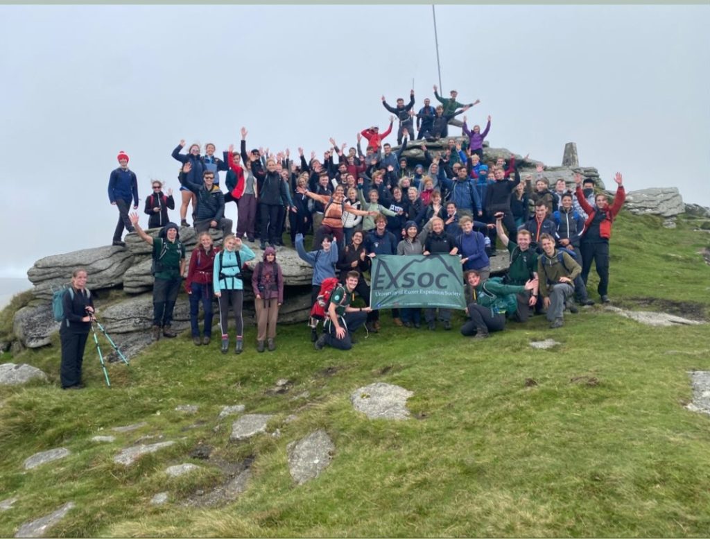 Large group of Expedition Society students at the top of a tor on Dartmoor.