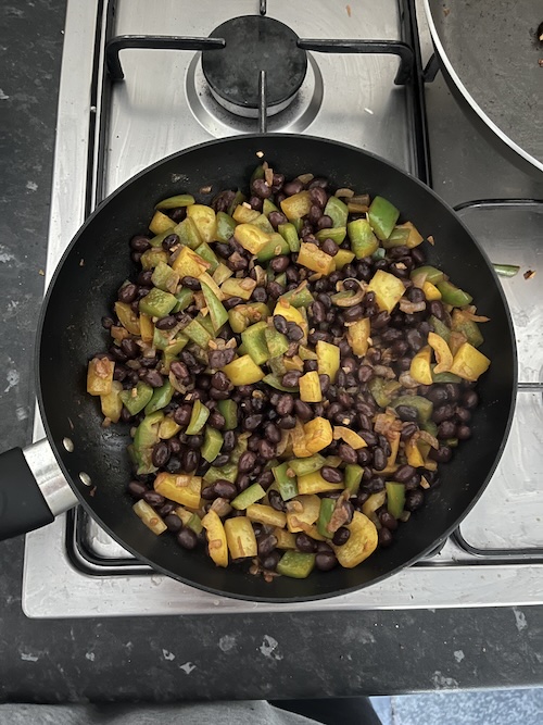 A pan with black beans and peppers